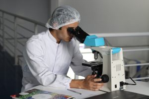 lab technician with a microscope used to perform pgd in cyprus analysis