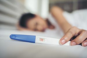 Sad woman with a negative pregnancy test after trying to conceive for more than a year
