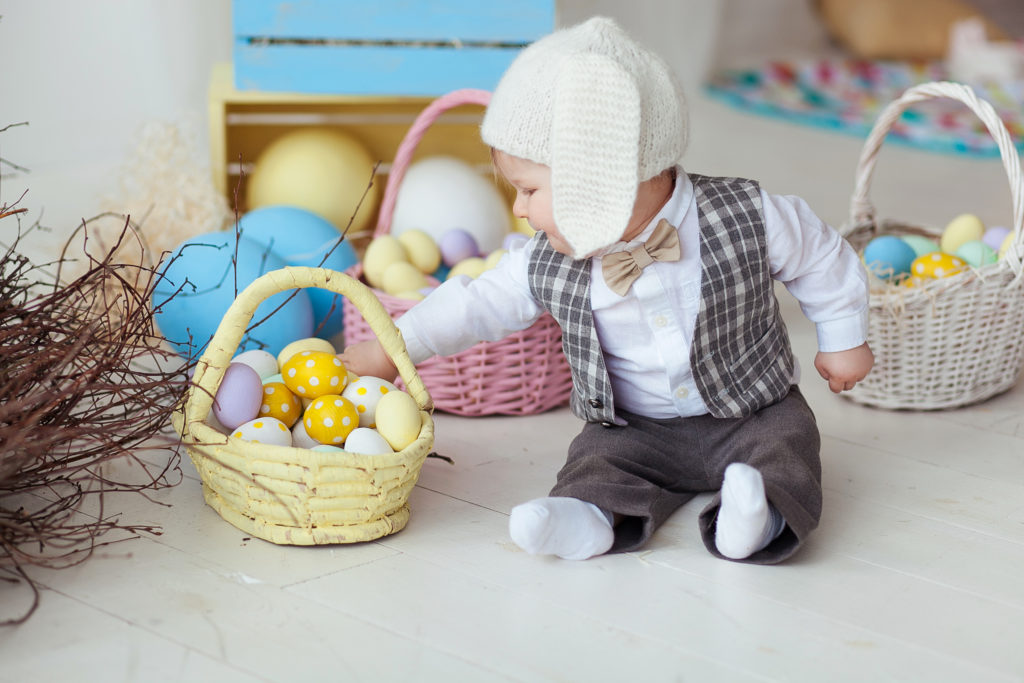 happy baby boy born via egg sharing treatment sitting around coloured eggs
