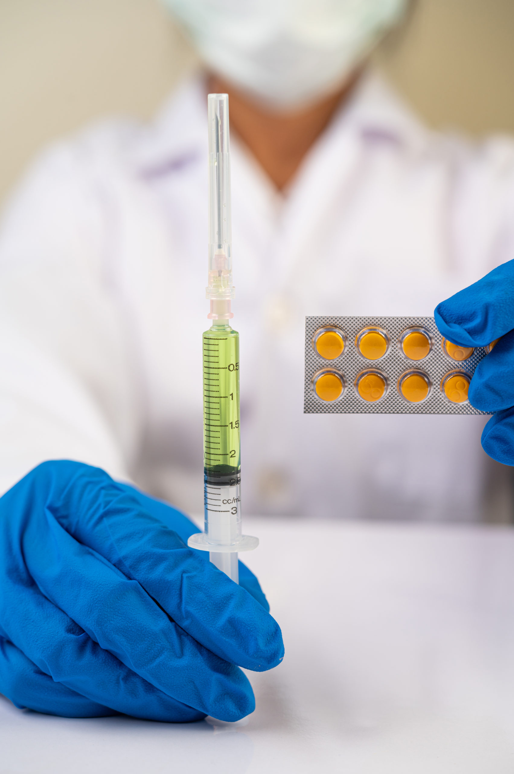 Scientists wearing masks and gloves Holding a syringe with a vac